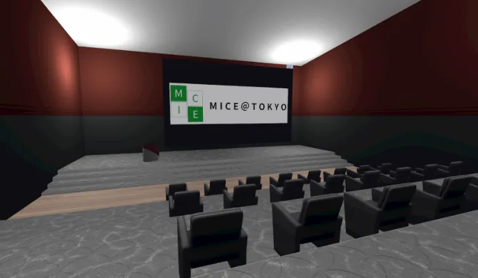 MICE@TOKYO内のシネマルーム。暗い照明の下、前方には「MICE@TOKYO」という文字とロゴがディスプレイされた大きなスクリーンが中央に配置されている。その前には小さな舞台があり、舞台の前にはゆったりとした黒い椅子が並べられ、着席スペースが提供されている。部屋の壁は赤と黒のデザインで、床には模様が施されたカーペットが敷かれている。